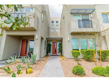 Contemporary townhouse featuring desert landscaping and a symmetrical facade with red doors at 1536 Unison Way # 102, Las Vegas, NV 89135