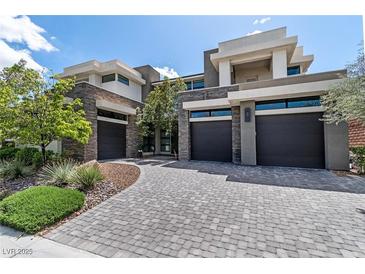 Stunning contemporary home featuring a stylish paved driveway and stone accents at 29 Owl Ridge Ct, Las Vegas, NV 89135