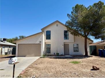 Two-story home with a two-car garage, neutral tones, and a xeriscaped front yard under a clear, blue sky at 5928 Willard St, Las Vegas, NV 89122