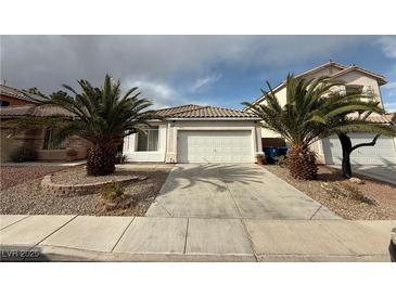 Charming single-story home featuring a two-car garage, desert landscaping, and mature palm trees at 7062 Russell Ranch Ave, Las Vegas, NV 89113