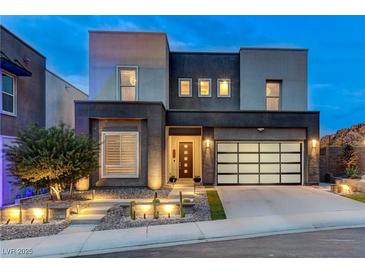 Contemporary home with a modern design, desert landscaping and a glass garage door at 746 Horizon Canyon Dr, Henderson, NV 89052