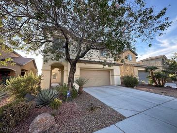 Two-story home with a two-car garage, desert landscaping, and a covered entryway at 8205 Celina Hills St, Las Vegas, NV 89131