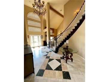 Stunning foyer with high ceilings, elegant chandelier, and grand staircase adds sophistication at 8690 W Ford Ave, Las Vegas, NV 89148