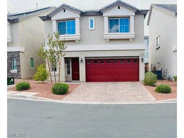 Charming two-story home with a red garage door and low maintenance landscaping at 10077 Cooper Mountain St, Las Vegas, NV 89141