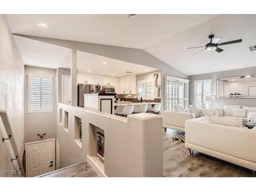 Bright, open-concept living room with white sofas, vaulted ceilings, and a glimpse of the kitchen area at 7250 Diamond Canyon Ln # 204, Las Vegas, NV 89149