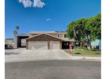 Charming two-story home featuring a three-car garage, brick accents, and a well-maintained lawn at 902 Dianne Dr, Boulder City, NV 89005