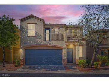 Charming two-story home featuring a blue garage door and a second-story balcony at 9066 Hilverson Ave, Las Vegas, NV 89148
