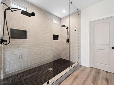 Modern bathroom featuring sleek glass shower, rainfall shower head, and mosaic tile floor at 8276 Aurora Peak Ave, Las Vegas, NV 89131
