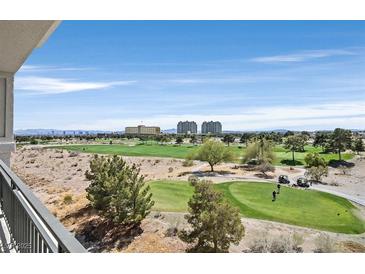 Beautiful golf course view from balcony with golf carts and players on the green under a vast blue sky at 9213 Las Manaitas Ave # 401, Las Vegas, NV 89144