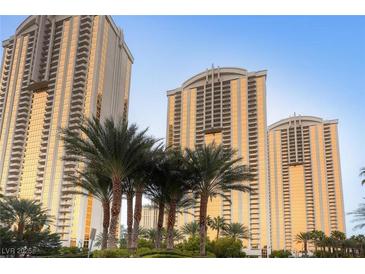 Stunning view of high-rise condo buildings with golden windows and tropical palm trees at 125 E Harmon Ave # 2215, Las Vegas, NV 89109