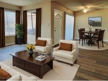Open living room features wood flooring, neutral paint, and updated furniture at 1450 Hialeah Dr # D, Las Vegas, NV 89119