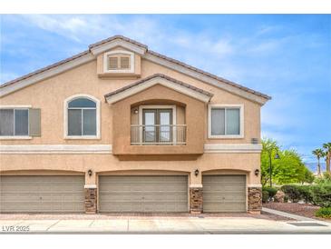 Inviting exterior view of a three-car garage townhome with a small, quaint balcony at 6617 Lavender Lilly Ln # 1, North Las Vegas, NV 89084