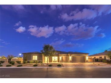 Charming single-story home featuring a three-car garage, desert landscaping, and inviting curb appeal at dusk at 8445 S Tenaya Way, Las Vegas, NV 89113