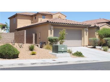 Tan two-story home showcasing a tile roof and a two-car garage at 932 Tafalla Ct, Las Vegas, NV 89138