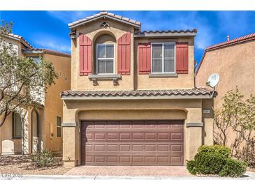 Inviting home featuring a two-car garage, red shutters, and desert landscaping in a suburban setting at 9343 Clear Day Ln, Las Vegas, NV 89178