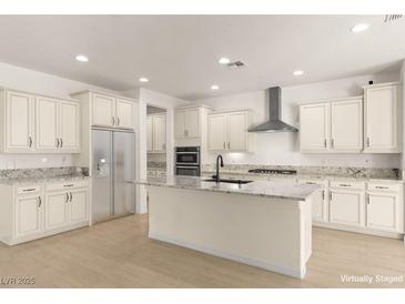 A bright kitchen boasts white cabinets, stainless steel appliances, and a large center island at 9519 Wild Valley Ave, Las Vegas, NV 89148