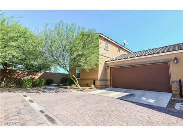 Charming single-Gathering home with a brick driveway, desert landscaping, and a two-car garage at 1035 Spotted Saddle St, Henderson, NV 89015