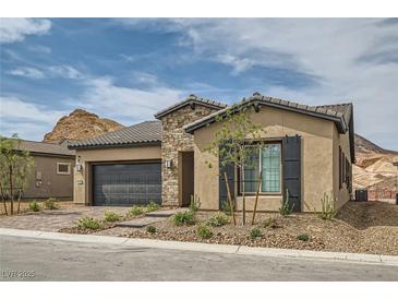 Beautiful single-story home featuring stone accents, a two-car garage, and desert landscaping at 138 Crimson Cactus Ave, Henderson, NV 89011