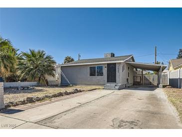 Charming single-story home featuring a spacious driveway and mature palm trees in a sunny, desert setting at 1645 Chestnut St, Henderson, NV 89011