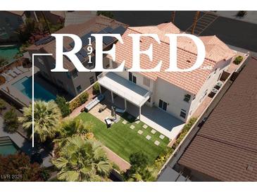 Stunning aerial view of a private backyard with plush lawn and covered patio seating at 191 Reed Ln, Henderson, NV 89074