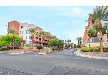 View of the beautiful condo community with landscaping and manicured grounds and attractive building exteriors at 23 E Agate Ave # 207, Las Vegas, NV 89123