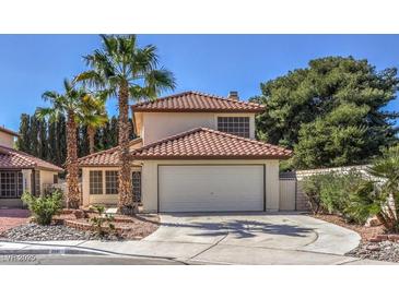 Charming two-story home with a tile roof, a two-car garage, and mature landscaping featuring palm trees at 2501 Muirfield Ave, Henderson, NV 89074