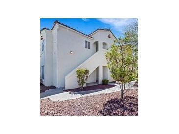 Inviting condo featuring well-maintained landscaping and a stucco facade with a staircase to the entrance at 698 S Racetrack Rd # 412, Henderson, NV 89015