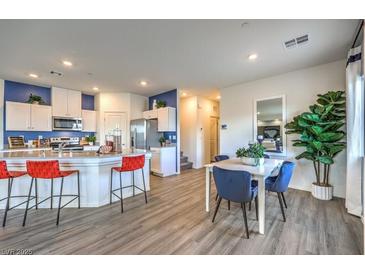 Bright dining area features modern table with seating for four, accented by a lush fiddle leaf fig plant at 7915 Pandora Sky St # 403, North Las Vegas, NV 89084