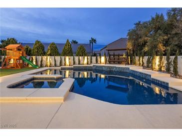 Beautiful backyard pool with a playset, manicured landscaping, and relaxing swing at 8000 Clock Tower Ct Ct, Las Vegas, NV 89117
