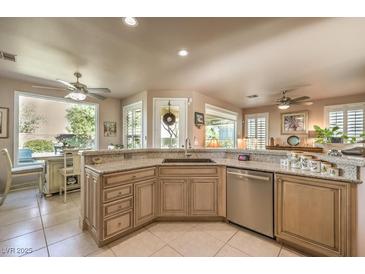 Well-lit kitchen featuring custom cabinets, granite countertops, stainless steel appliances, and a breakfast nook at 10290 Profeta Ct, Las Vegas, NV 89135
