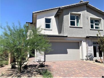 Charming two-story home with a two-car garage, brick driveway, and desert landscaping in a sunny setting at 116 Antler Square Ln, Henderson, NV 89011