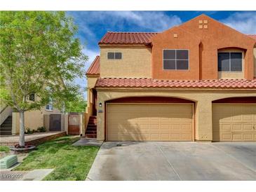 Two-story home showcasing a two-car garage, red tile roof, and well-maintained lawn with a tree at 1660 Cloister Ave, Henderson, NV 89014