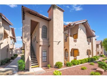 Charming condo exterior with a tile roof, red rock landscaping, and private stair access at 4097 Nook Way # A, Las Vegas, NV 89103