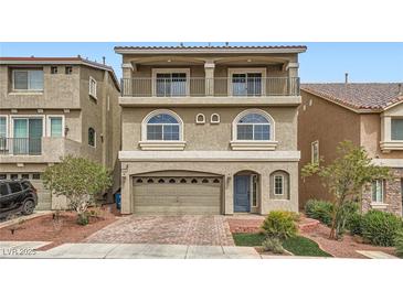 Charming three-story home features a balcony, arched windows, neutral stucco, and a two car garage at 5340 Kennedy Hill Ave, Las Vegas, NV 89139