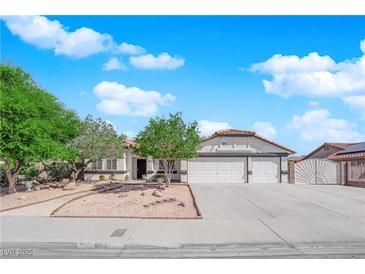 Charming single-story home featuring a three car garage, desert landscaping and a tile roof at 6150 W Brooks Ave, Las Vegas, NV 89108