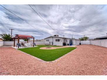 Large backyard featuring low maintenance landscaping and an outdoor seating area at 6232 Bristol Way, Las Vegas, NV 89107