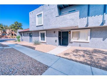 Charming two-story condo features well-maintained landscaping, stucco exterior, and a concrete pathway at 1326 N Jones Blvd, Las Vegas, NV 89108