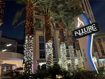 Night view of Allure Las Vegas entrance, featuring palm trees adorned with lights and the building's signage at 200 W Sahara Ave # 2211, Las Vegas, NV 89102