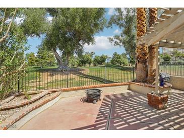 Spacious back patio boasting a fire pit and lush golf course views, perfect for outdoor relaxation at 3177 Bel Air Dr, Las Vegas, NV 89109