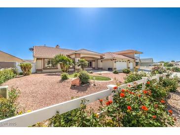Charming single story home featuring a spacious front yard, three car garage and colorful rose bushes at 5231 E Chasemoor St, Pahrump, NV 89061