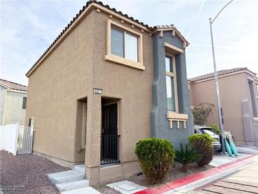 Inviting two-story home featuring a neutral stucco facade, complemented by well-kept landscaping at 5271 Aurora Beam Ave, Las Vegas, NV 89122