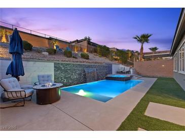 Inviting pool and spa with waterfall feature and lounge area, perfect for relaxing evenings at 18 Via Tiberina, Henderson, NV 89011