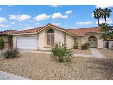Charming single-story home with a tile roof, stucco exterior, and desert landscaping at 1830 Ginger Blossom Ave, North Las Vegas, NV 89031