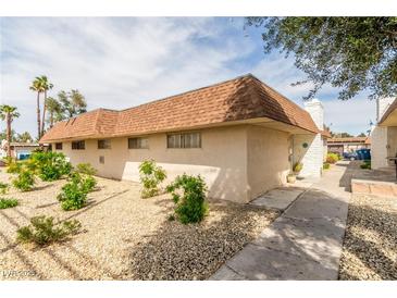 View of the home's exterior with low maintenance desert landscaping and a brick chimney on a sunny day at 2645 Heritage Ct, Las Vegas, NV 89121