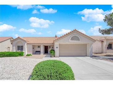 Charming single-story home features a well-maintained front yard with desert landscaping and an attached two-car garage at 3000 Morning Ridge Dr, Las Vegas, NV 89134