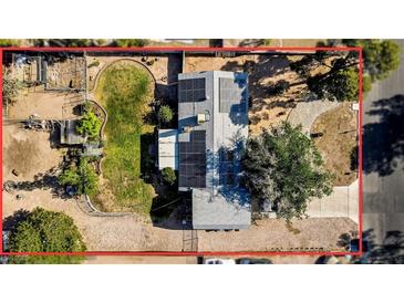An aerial view of a home featuring a solar-paneled roof, established trees, fenced yard and long driveway at 3100 Garehime St, Las Vegas, NV 89108