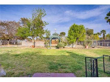 Spacious backyard featuring a charming gazebo, mature trees, and well-maintained lawn at 3100 Garehime St, Las Vegas, NV 89108