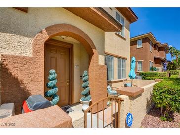 Charming two-story townhome featuring a front door with decorative spiral topiary and a cozy front patio at 3840 Belle Glade St # 104, Las Vegas, NV 89129