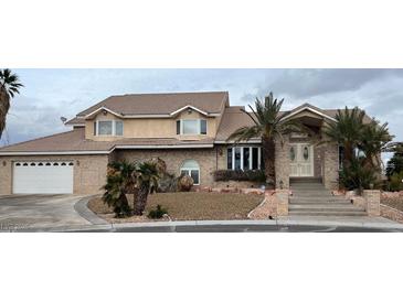 Stately two-story brick home featuring a tile roof, front-facing garage, and desert landscaping at 5770 El Camino Rd, Las Vegas, NV 89118