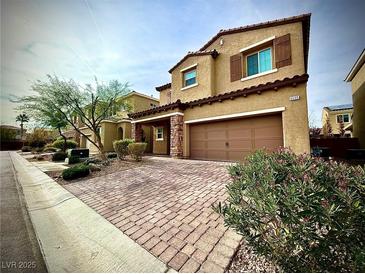 Charming two-story home with a brick driveway, attached garage, and well-manicured landscaping at 6639 Ivory Dove Ct, Las Vegas, NV 89148